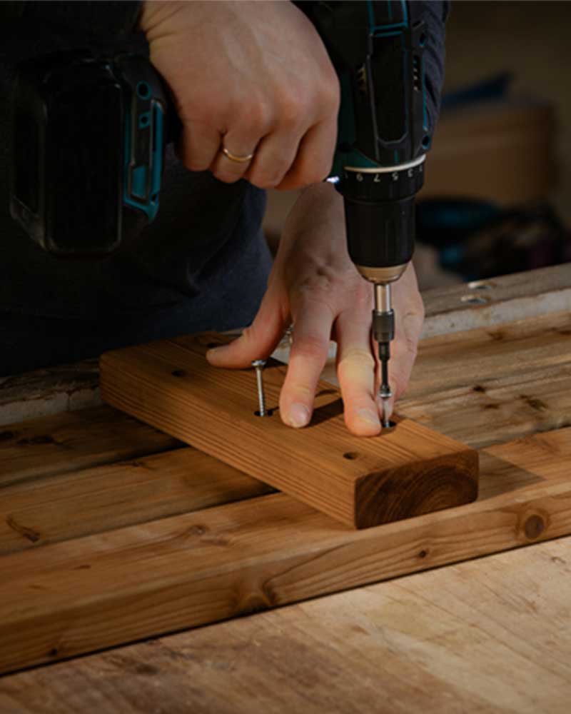 Closeup of wooden plank being fastened in a bigger piece